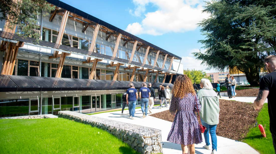 Plusieurs groupes de personnes se dirigeant vers l'arrière du batiment de la bibliothèque de Belfort