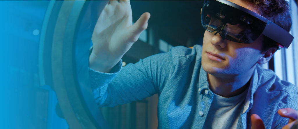 Gros plan montrant un jeune homme portant un casque de réalité mixte (un HoloLens 2 de Microsoft) et interagissant activement avec une projection holographique d'un engrenage complexe