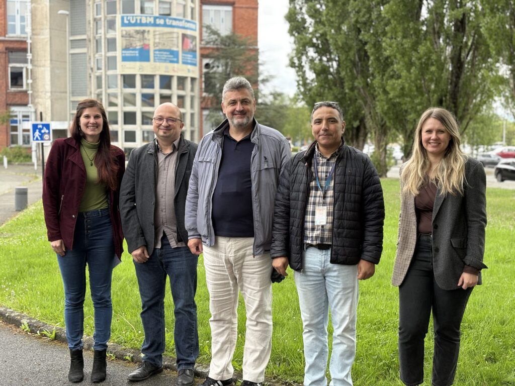 5 femmes et hommes posant devant la tour de l'UTBM Belfort