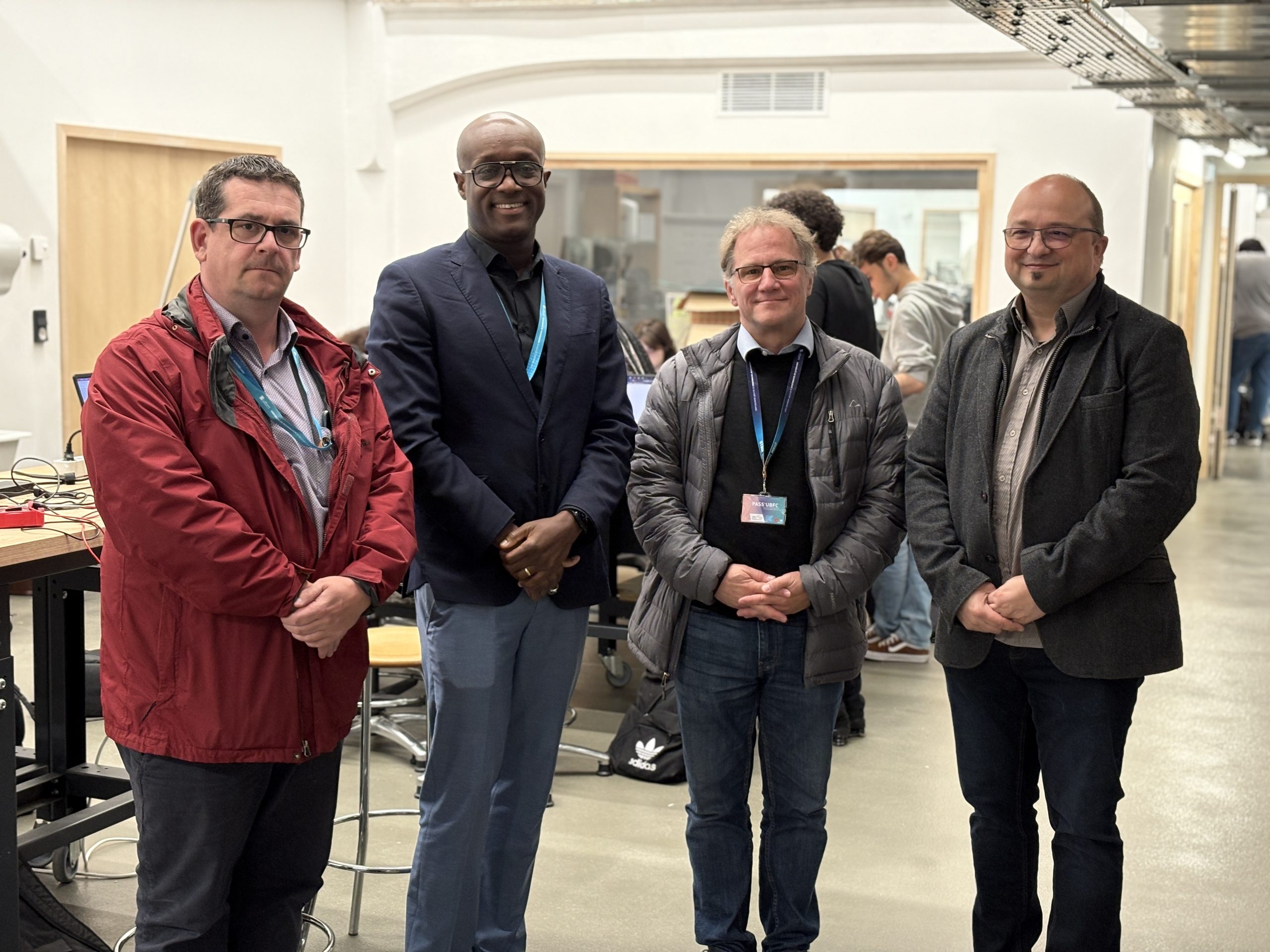 Photo de groupe dans les locaux du CrunchLab, 4 hommes personnels UTBM posent.