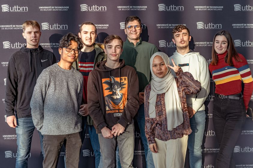 Photo d'un groupe d'étudiants devant un photocall UTBM