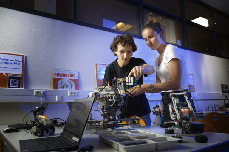 Deux étudiants travaillant sur la fabrication d'une machine, dans un laboratoire