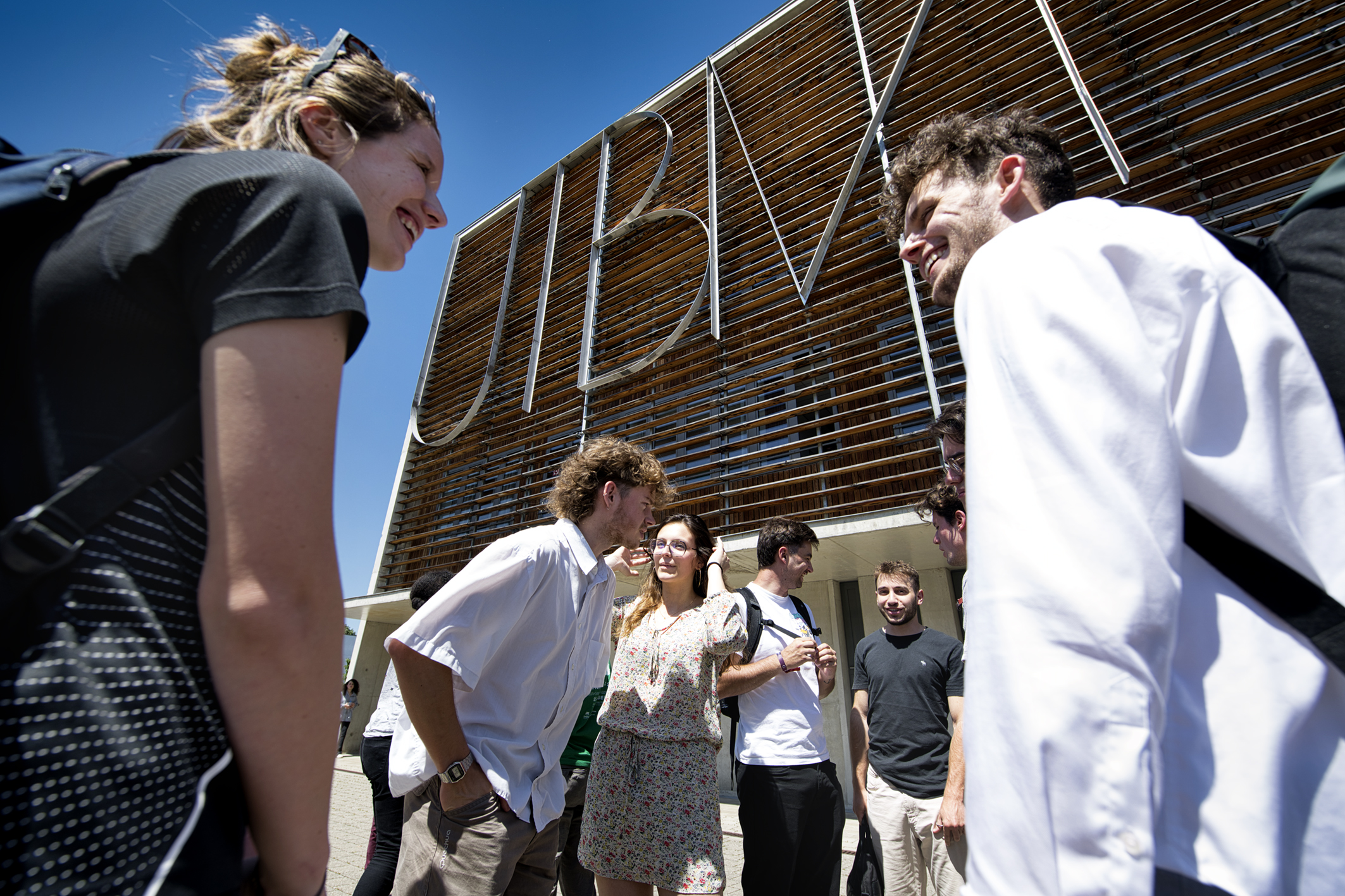 Un groupe d'étudiants en extérieur devant le batiment de l'UTBM de Montbéliard