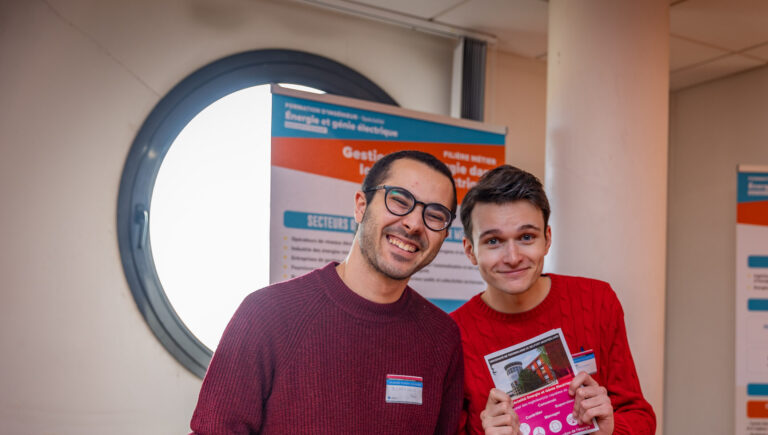 Deux étudiants souriant présentant l'UTBM pendant la journées portes ouvertes