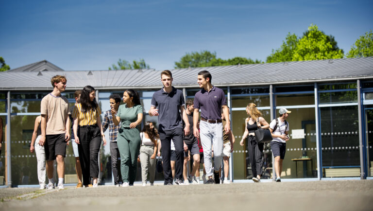 Un groupe d'étudiants marchant de face, en extérieur
