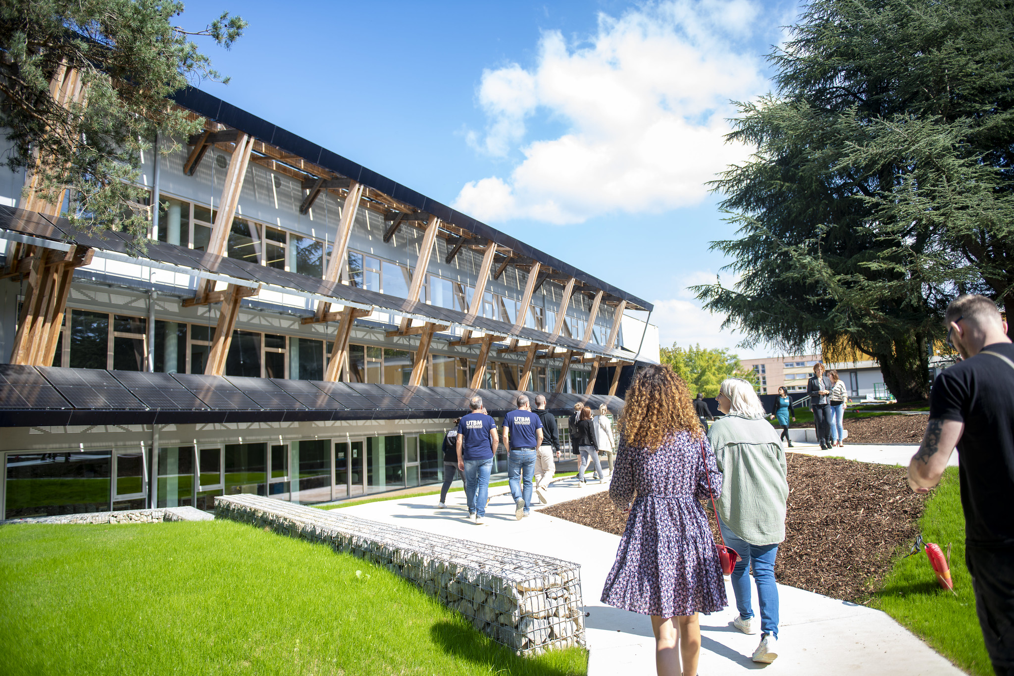 Groupe de personnes se dirigeant vers un batiment UTBM