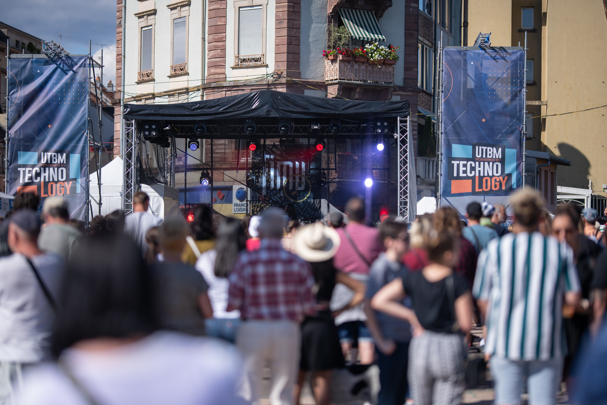 Scène du FIMU en centre ville de Belfort. Des festivaliers sont au premier plan